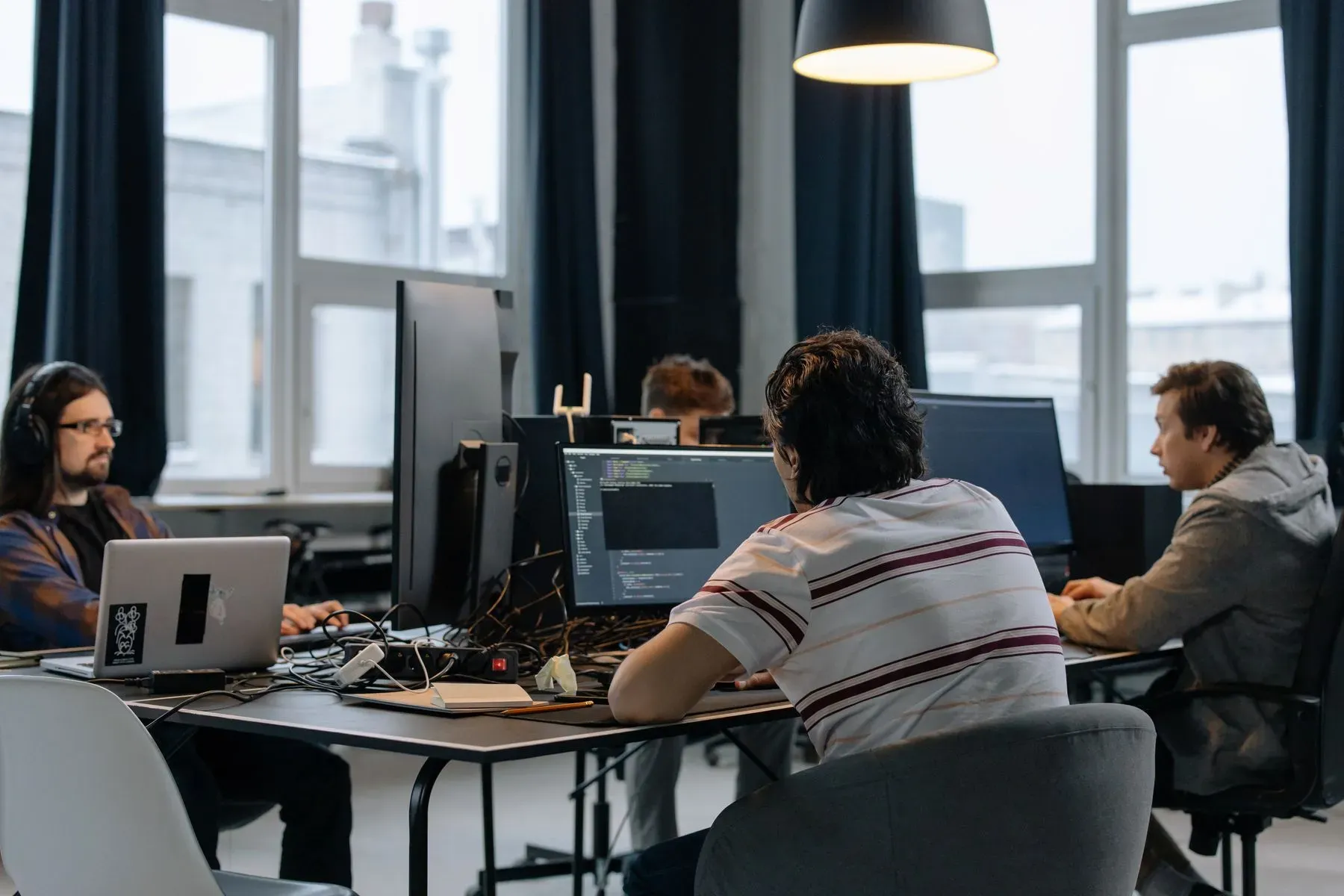 Team arbeitet konzentriert an mehreren Bildschirmen